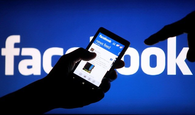 A smartphone user shows the Facebook application on his phone in the central Bosnian town of Zenica, in this photo illustration, May 2, 2013. Facebook Inc's mobile advertising revenue growth gained momentum in the first three months of the year as the social network sold more ads to users on smartphones and tablets, partially offsetting higher spending which weighed on profits. REUTERS/Dado Ruvic (BOSNIA AND HERZEGOVINA - Tags: SOCIETY SCIENCE TECHNOLOGY BUSINESS)