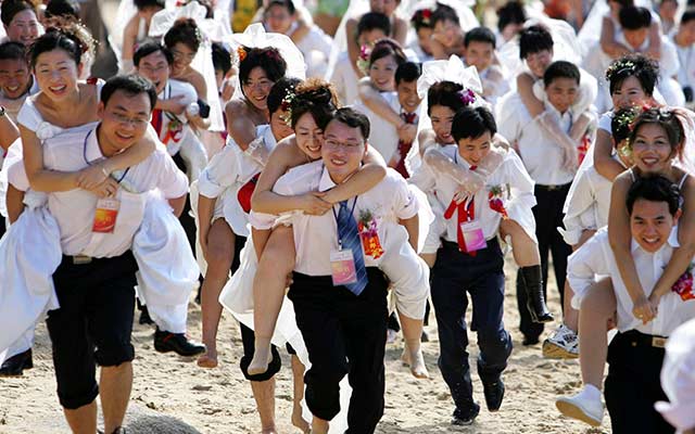 During-a-mini-marathon-celebrating-the-New-Year-grooms-run-with-their-brides-in-Sanya-in-south-Chinas-Hainan-province-